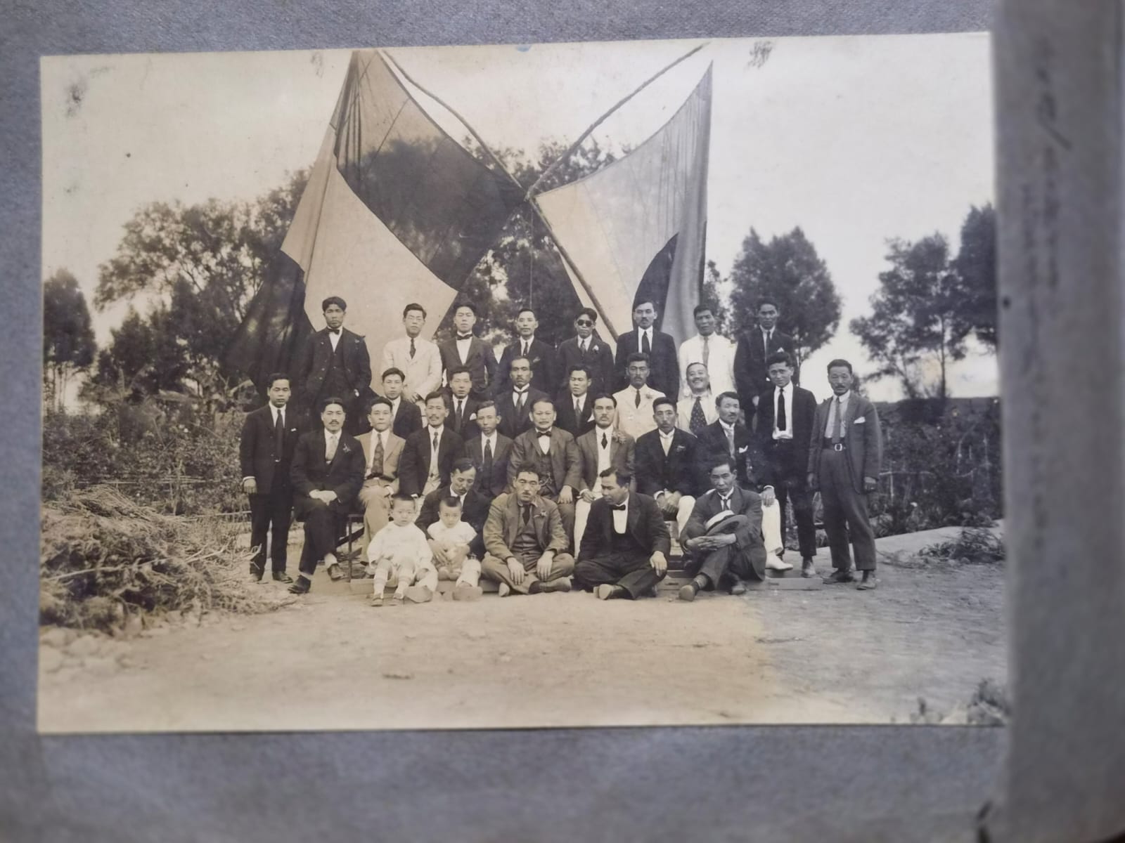 Grupo de personas reunidas con banderas de Perú y Japón en una fotografía histórica de la inmigración japonesa en el Perú.